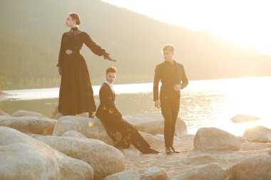 Aşk üçgeni. Güzel bir kadın ve zarif siyah elbiseli iki yakışıklı deniz kenarında dururlar. Birbirlerinden ayrı aşk duyguları ve karmaşık ilişkileri yüzünden işkence görürler..