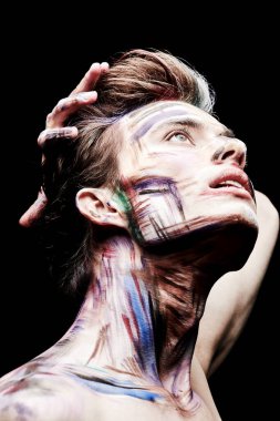 Siyah bir arka planda, renkli tenli yakışıklı bir sarışının portresi. Sanat, moda ve vücut boyası.