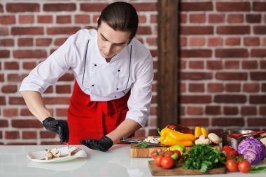 Yakışıklı profesyonel aşçı restoranın mutfağında nefis bir tabak taze sebze hazırlıyor. Yemek ve yemek..