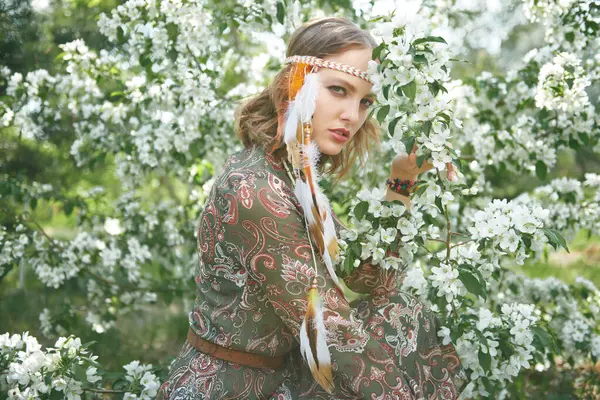 Doğada çiçek açan ağaçların tadını çıkaran narin, güzel bir kız. Romantik tarzda. Güzellik ve moda, bohem tarzı. Bahar mevsimi.