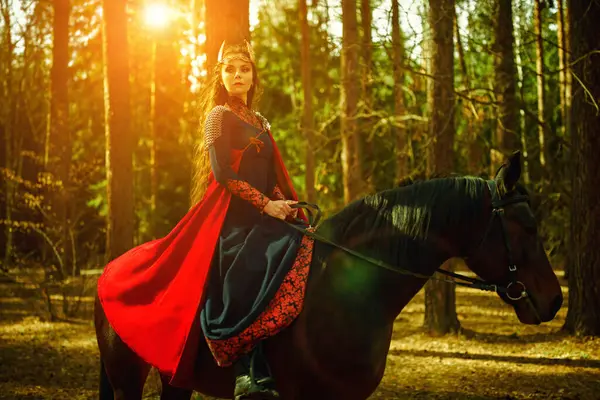 Güzel kadın savaşçı Valkyrie savaş atıyla güneş ışığıyla aydınlatılan ormanda at sürüyor. İskandinav mitolojisi. Eski efsaneler.