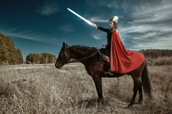 İskandinav mitolojisi. Fantezi. Savaşa hazırlanan çok güzel bir Valkyrie elinde kılıçla bir savaş atının üzerinde oturuyor.. 