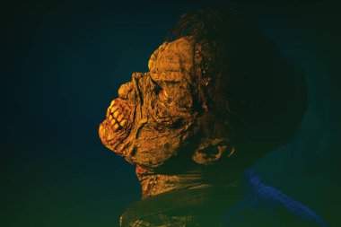 Çirkin kanlı bir zombi kameraya doğru dönüyor. Siyah bir arkaplanda yakın plan portresi.