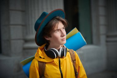 Sırtında sırt çantasıyla gezip şehri gezen modern bir gencin portresi. Çocuk ve ergen turizmi, tatiller. Etkin yaşam biçimi.