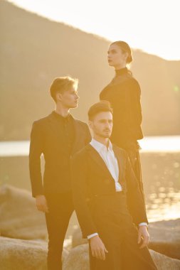 Aşk üçgeni. Güzel bir kadın ve zarif siyah elbiseli iki yakışıklı deniz kenarında dururlar. Birbirlerinden ayrı aşk duyguları ve karmaşık ilişkileri yüzünden işkence görürler..