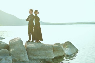 Güzel bir kadın ve yakışıklı bir adamın yan görüntüsü. Deniz kenarında durup birbirlerine sırt çeviriyorlar. Sevgi dolu bir ilişki. Drama, aşk romanı. 