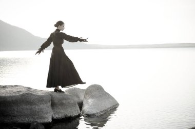 Zarif siyah elbiseli güzel bir kadın iç acılarından ve acılarından kurtulmak için kendini denizde boğacak. 19. yüzyıl romanı. Siyah ve beyaz atış. Boşluğu kopyala. 