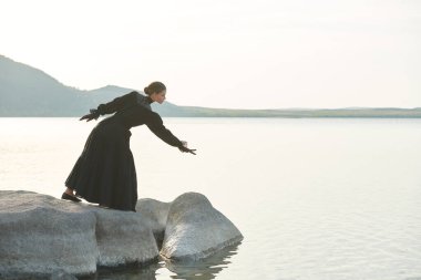 Zarif siyah elbiseli güzel bir kadın iç acılarından ve acılarından kurtulmak için kendini denizde boğacak. 19. yüzyıl romanı. Boşluğu kopyala. 