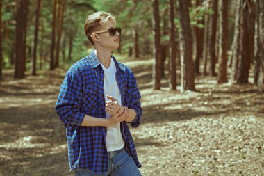 Bir turist yürüyüşçüsü çam ormanında yol boyunca yürür. Turizm, doğa keşfi. Yaz tatili. 