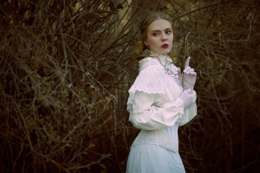 Tarihsel mistik roman. Beyaz dantel elbiseli güzel bir aristokrat bayan kale parkında dikiliyor ve kenarda temkinli görünüyor. Viktorya tarzı.