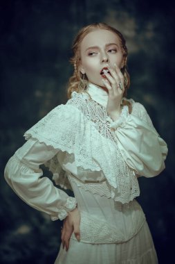 Zarif beyaz dantel elbiseli güzel bir aristokrat kadın koyu bir arka planda poz veriyor. Viktorya dönemi. Moda, saç stili ve makyaj. Tarihi roman..