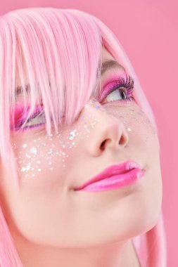 Asya anime tarzı. Pembe saçlı, parlak pembe çilli neşeli ve güzel bir genç kızın portresi. Saç stili, kozmetik ve makyaj.