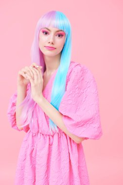 Parlak makyajlı, menekşe mavisi peruklu, şık pembe elbiseli tatlı bir kız. Pembe arka plan. Moda. Saç stili, saç boyası, makyaj. Japon animasyon tarzı. 