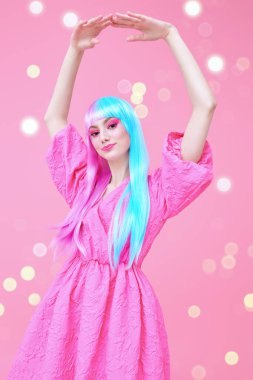 Parlak makyajlı, menekşe mavisi peruklu, şık pembe elbiseli hoş bir kız. Pembe arka planda parlayan ışıklar. Moda. Saç stili, saç boyası, makyaj. Japon animasyon tarzı. 