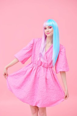 Japon animasyon tarzı. Parlak makyajlı, menekşe mavisi peruklu, şık pembe elbiseli güzel bir kız. Pembe arka plan. Moda. Saç stili, saç rengi, makyaj..