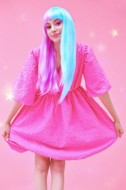 Japon animasyon tarzı. Parlak makyajlı, menekşe mavisi peruklu, şık pembe elbiseli güzel bir kız. Yıldızlı pembe arka plan. Moda. Saç stili, saç rengi, makyaj..