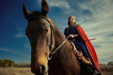 Görkemli kadın savaşçı Valkyrie savaş atıyla savaş alanında at sürüyor. İskandinav mitolojisi. Eski efsaneler.