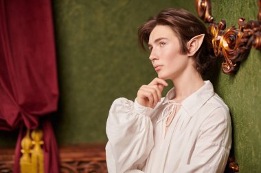 Sihirli kalesinde düşünceli bir şekilde duran yakışıklı bir elf çocuğunun portresi. Fantezi. Peri masalı, sihir. 