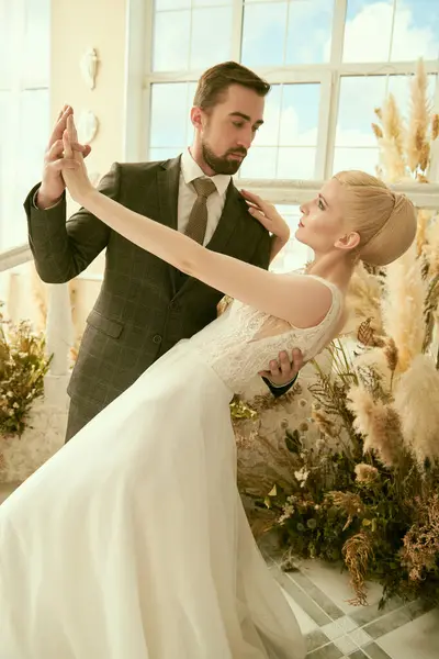 stock image Wedding couple. Portrait of an elegant bride and groom dancing and looking at each other in Mediterranean-style apartment. Wedding fashion, elegant style.