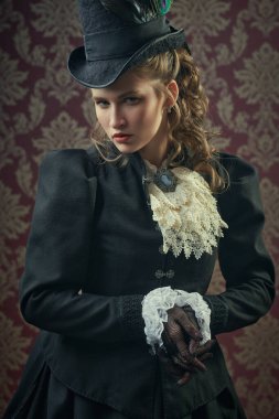 19. yüzyıl elbisesi içinde şık kırmızı gözlük ve güzel şapkayla poz veren zarif bir Victoria kadınının klasik portresi. 19. yüzyıl moda ve güzelliği.