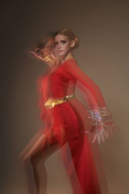 Göz kamaştırıcı bayan dansçı, parlak mücevherleri olan zarif kırmızı elbiseler içinde Latin dansı yapıyor. Moda ve güzellik. Bale gösterisi. Stüdyo resmi.