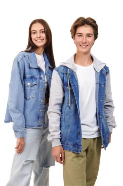 Gençler için Denim modası. Beyaz arka planda modaya uygun giyinmiş neşeli genç bir erkek ve genç bir kızın moda çekimi.. 