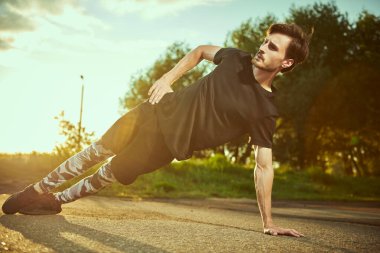 Atletik bir adam gün batımında dışarıda egzersiz yapıyor. Aktif ve sağlıklı bir yaşam tarzı. Spor hobileri.