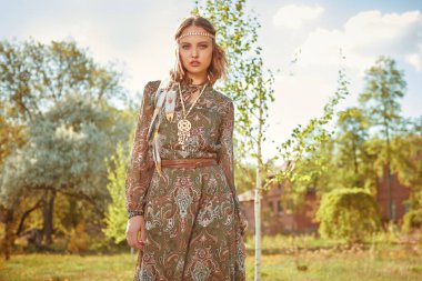 Güzel, kadınsı bir kız kırsalda boho tarzı kıyafetler ve aksesuarlarla poz veriyor. Romantik tarzda. Güzellik ve moda, bohem tarzı. Boşluğu kopyala.