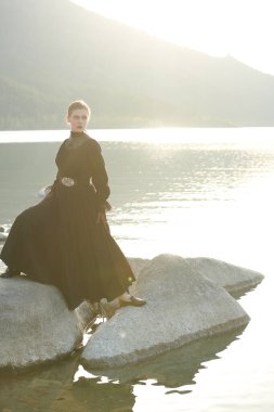 Zarif siyah elbiseli güzel bir kadın iç acılarından ve acılarından kurtulmak için kendini denizde boğacak. 19. yüzyıl romanı. Boşluğu kopyala. 