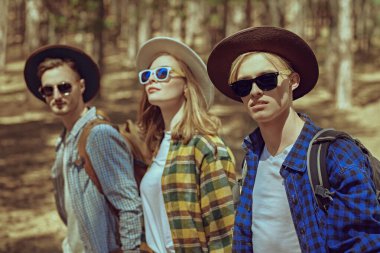 Yaz tatili. Bir grup genç turist çam ormanında yürüyüşe çıkar. Mutlu yaz günleri. Yaz stili.