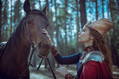 İskandinav mitolojisi. Fantezi. Güzel bir valkyrie ormanda dururken atıyla konuşuyor.. 