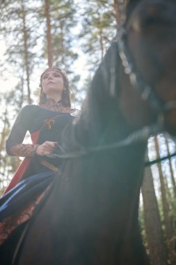 Güzel kadın savaşçı Valkyrie savaş atıyla ormanda at sürüyor. İskandinav mitolojisi. Eski efsaneler.