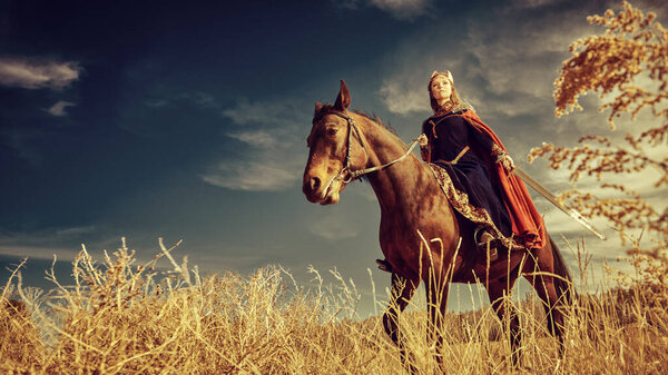 Древние легенды. Величественная женщина-воительница Валькирия проезжает через поле боя на своем боевом коне. Скандинавская мифология. 