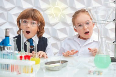 Çocukların erken gelişimi. Laboratuvarda bilimsel deneyler yapan iki heyecanlı çocuk. Eğitici kavram. 
