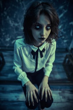 Cadılar Bayramı. Dehşet. Eski demir bir yatakta yalnız oturan korkunç bir kızın portresi.. 