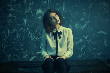 Cadılar Bayramı. Dehşet. Eski demir bir yatakta yalnız oturan korkunç bir kızın portresi.. 