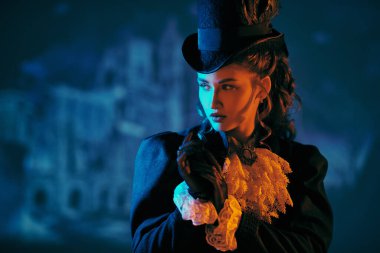 Geceleyin kasvetli, eski bir kalenin yanında duran 19. yüzyıldan kalma genç bir bayan. 19. yüzyılın sonları, 20. yüzyılın başları. Cadılar Bayramı. Korku, gerilim. Vampirler. Boşluğu kopyala.