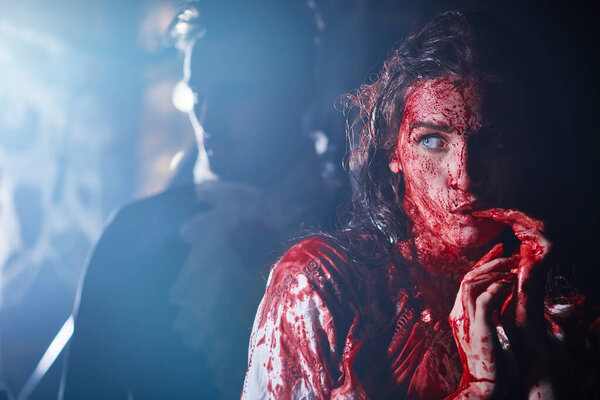 Портрет дракулы с женщиной-жертвой, пропитанной кровью после укуса в мрачной комнате старого замка. Ужас, триллер. Хэллоуин. Вампиры. Копирование пространства.