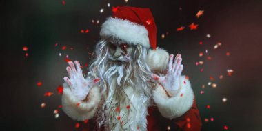 Korkunç bir zombi Noel Baba portresi kanlı sakallı ve gözü yanan, kameraya bakıp şeytanca gülen. Siyah arka plan ve şenlikli konfeti. Noel, Yeni Yıl ve Cadılar Bayramı.