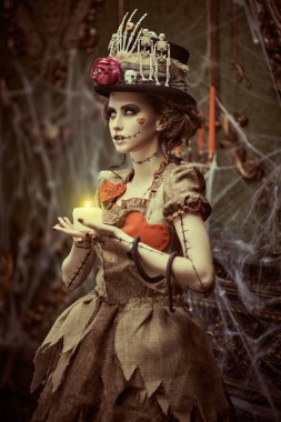 Voodoo büyüsü. Esrarengiz ve korkutucu bir kızın portresi voodoo bebeği gibi giyinmiş, kasvetli eski bir kalede örümcek ağlarıyla kaplı duruyor. Cadılar Bayramı.