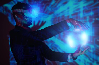 Modern iş konsepti. Sanal Gerçeklik gözlüklü başarılı bir işadamı işinin 3 boyutlu hologramını yönetir. Geleceğin bilgi teknolojileri.