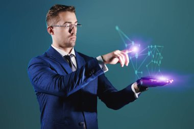 Dijital bir hologramı yöneten ciddi bir erkek işadamı veya politikacının portresi. Yeşil arkaplan.