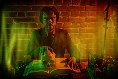 Yüzünde yara izleri olan çirkin bir adam. Laboratuvarında eski el yazmaları ve mataralarla çalışan takıntılı bir bilim adamı. Bir ortaçağ simyacısı gençlik iksirini arıyor. Cadılar Bayramı. 