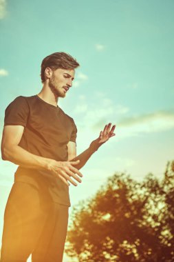 Aktif yaşam tarzı. Eğitimden sonra dışarıda dikilen ve bir şeyler düşünen genç bir adamın portresi..
