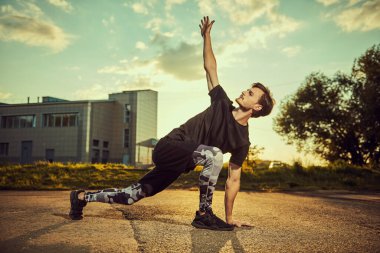 Aktif bir genç adam gün batımında parkta antrenman yapıyor. Spor ve spor. Etkin yaşam biçimi.