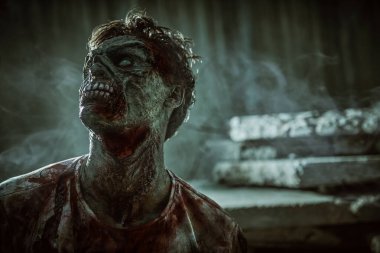 Zombi kıyameti. Sinirli kanlı zombi adam fotokopi alanı olan kasvetli kirli bir arka plana karşı. Cadılar Bayramı. Korku filmi. 