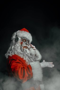 Zombiler için Noel partisi. Korkunç ve havalı DJ Noel Baba zombi dans eder ve kulaklıkla şarkı söyler. Kopyalama alanı olan siyah arkaplan. Cadılar Bayramı. 