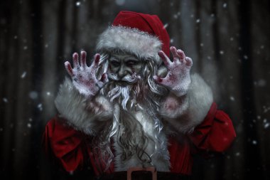 Korkunç bir zombi Noel Baba portresi kanlı sakallı ve gözü yanan, kameraya bakıp şeytanca gülen. Siyah arka plan ve şenlikli konfeti. Noel, Yeni Yıl ve Cadılar Bayramı. Boşluğu kopyala.