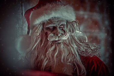 Kanlı sakallı korkunç Noel Baba 'nın portresi karla kaplı ahşap bir kulübede duruyordu. Noel, Yeni Yıl ve Cadılar Bayramı.