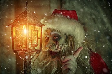 Korkunç bir Noel Baba zombisinin portresi. Geceleri kar yağarken fenerin başında dikilip sinsice gülüyor. Noel 'de kabus. Cadılar Bayramı.
